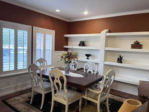 Living/Dining area with dark wood-type flooring, crown molding, and recessed lighting