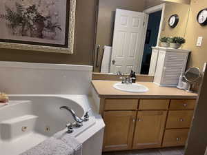Primary bathroom with vanity, a whirlpool tub, and tile patterned floors