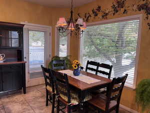 Dining room with a chandelier and light tile patterned flooring