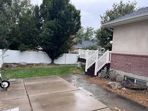 Fenced backyard with a wooden deck, patio