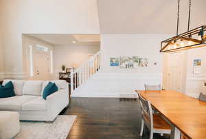 Dining room featuring a decorative wall, dark wood-type flooring, stairway, wainscoting, and recessed lighting