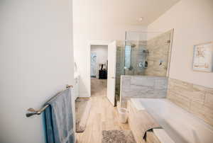 Full bathroom with a garden tub, a shower stall, vanity, and light wood-style floors