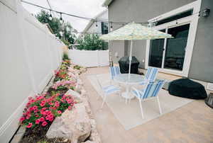 Fenced backyard with a patio area, outdoor dining area, and grilling area