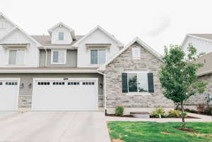 Craftsman inspired home with stone siding, driveway, an attached garage, and a shingled roof