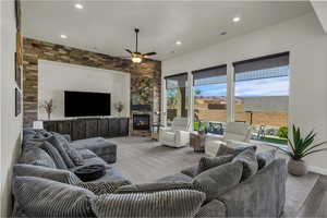 Living area featuring a fireplace, ceiling fan, and recessed lighting