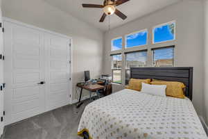 Carpeted bedroom with a closet, an office area, and ceiling fan