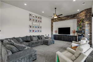 Living room featuring carpet flooring, a fireplace, recessed lighting, and a ceiling fan