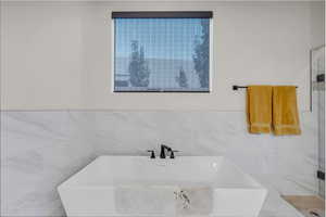 Bathroom with a freestanding tub and tile walls