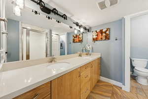 Full bath with double vanity and a stall shower