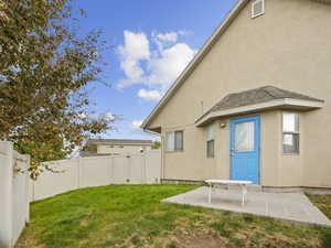Back of property featuring stucco siding, a patio area, and a fenced backyard