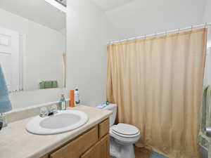 Bathroom featuring vanity, a textured ceiling, and lofted ceiling