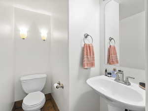 Half bathroom with toilet and tile patterned flooring