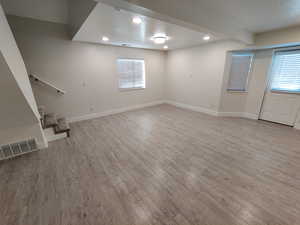 Basement featuring a textured ceiling, recessed lighting, stairs, and light wood-type flooring