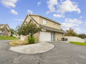 View of front of home with asphalt driveway, stucco siding, and an attached garage