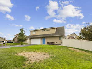Rear view of house with stucco siding, asphalt driveway, and a shingled roof