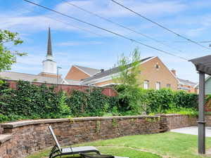 Backyard with paved pergola area adjacent to church lot with direct gate access (up the stairs)