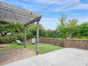 Backyard with paved pergola area adjacent to church lot with direct gate access (up the stairs)