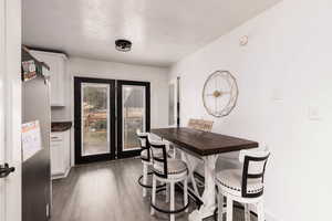 Dining area with dark wood-type flooring and a textured ceiling