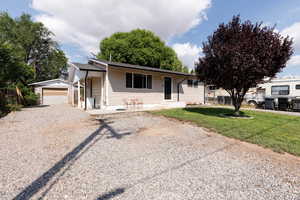 View of front facade with an outbuilding, driveway, and a garage