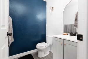 Half bathroom featuring vanity and wood finished floors
