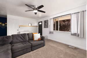 Living area with carpet flooring and a ceiling fan