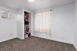 Unfurnished bedroom featuring baseboards and carpet