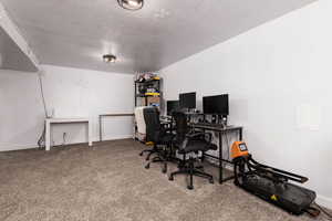Office area featuring carpet floors and a textured ceiling