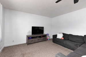 Living area featuring carpet floors and ceiling fan