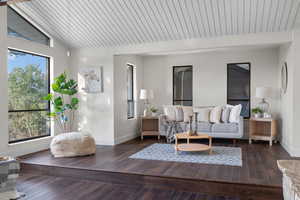 Living room with dark wood-type flooring and wooden ceiling