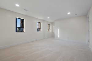 Spare room with recessed lighting, healthy amount of natural light, and light colored carpet