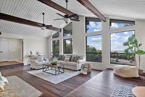 Living area with high vaulted ceiling, dark wood finished floors, and beamed ceiling