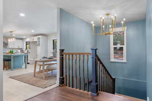 Stairs with a chandelier and recessed lighting