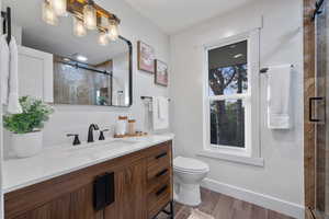 Full bath featuring vanity, a shower stall, and wood tiled floors