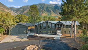View of front facade with brick siding, a standing seam roof, a metal roof, a mountain view, and a garage
