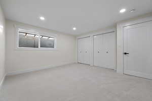 Unfurnished bedroom featuring light carpet, multiple closets, and recessed lighting
