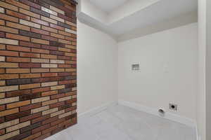 Laundry area with tile patterned flooring, hookup for an electric dryer, and hookup for a washing machine