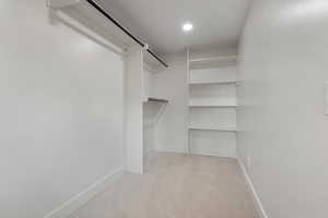 Spacious closet with light colored carpet