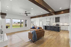 Living area with recessed lighting, beamed ceiling, light wood finished floors, a ceiling fan, and a mountain view