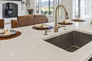 Kitchen featuring light stone countertops and a wood stove