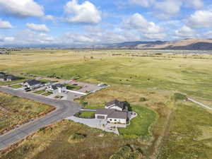 Aerial view of property and surrounding area featuring rural landscape and a mountain backdrop