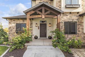 Entrance to property featuring stone siding and stucco siding