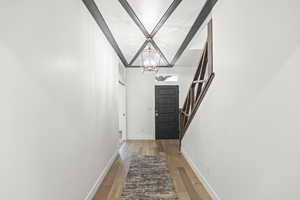 Doorway with hardwood / wood-style flooring, stairs, and a chandelier