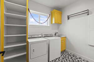 Washroom with washing machine and dryer, cabinet space, and light flooring