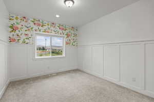 Empty room featuring a decorative wall, a wainscoted wall, carpet flooring, wallpapered walls, and recessed lighting