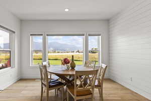 Dining room featuring light wood finished floors, a mountain view, recessed lighting, and wood walls