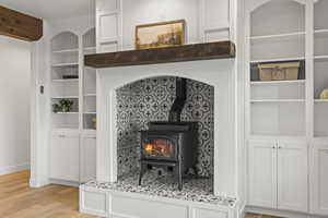 Detailed view of built in features, a wood stove, and wood finished floors