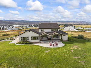 Back of house featuring stucco siding, a patio area, and a mountain view