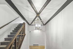 Staircase with a chandelier and wood finished floors