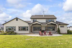 Back of property featuring a patio, stucco siding, and a yard