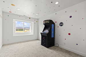 Recreation room with light colored carpet and recessed lighting